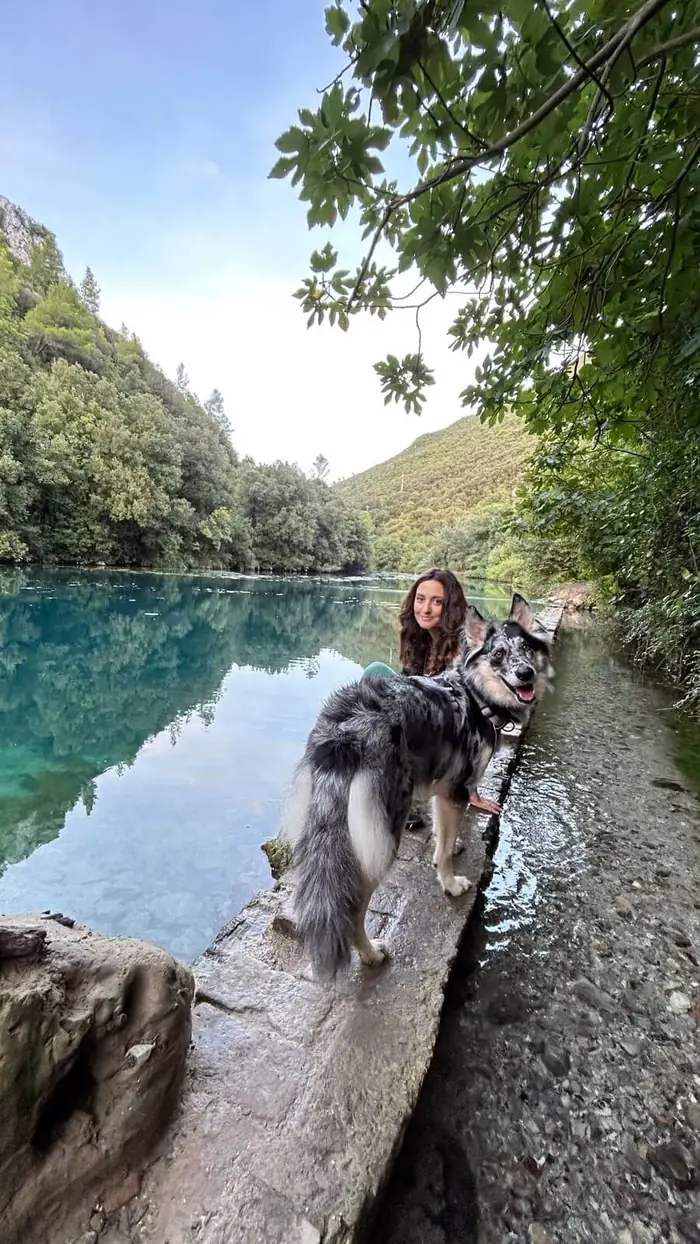 Lisa in riva al lago insieme a un pastore australiano